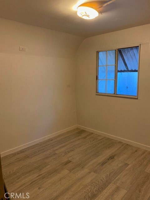 2767 West 1st Street, Unit 26 Santa Ana, CA 92703 - Photo 10 of 15 an empty room with wooden floor and window