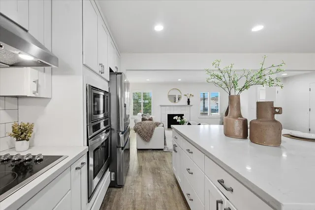 a kitchen with stainless steel appliances granite countertop a kitchen island a stove a table and chairs