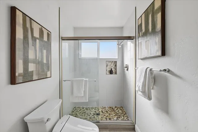 a patio with table and chairs and couches with wooden fence