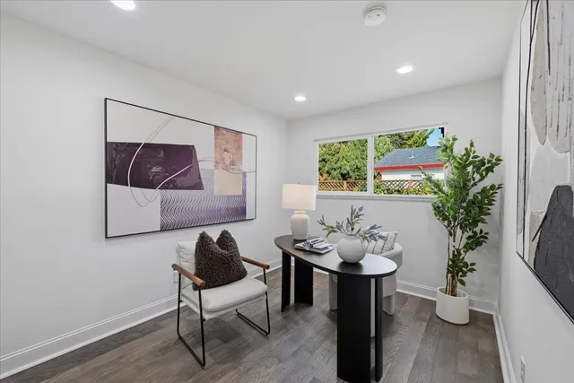 a patio with a table and chairs and potted plants