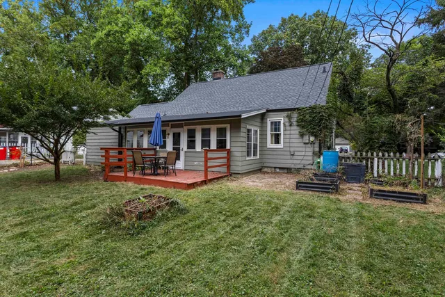 a view of a house with backyard and a tree