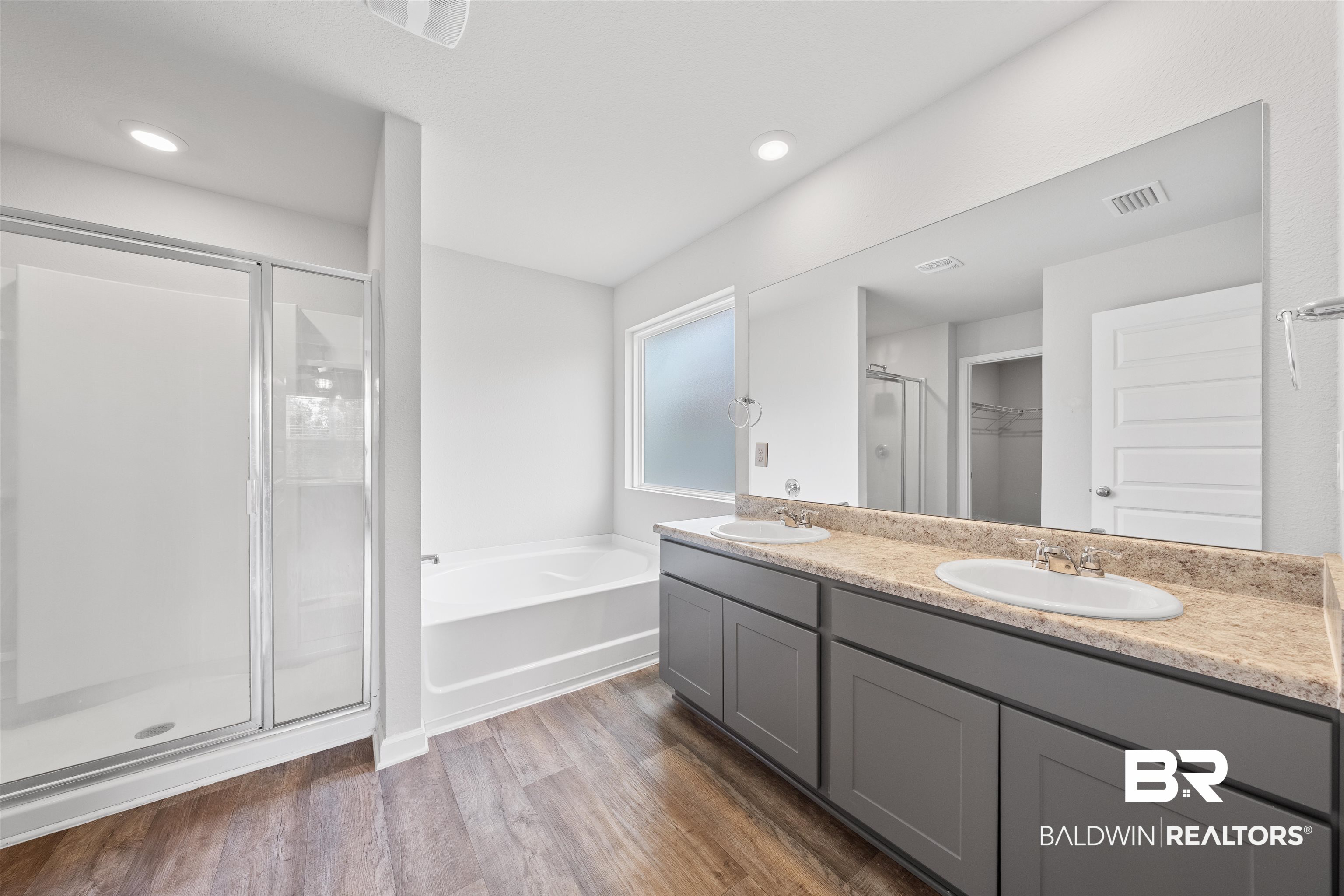 7457 Brompton Drive Foley, AL 36535 - Photo 12 of 24 Full bathroom featuring double vanity, dark wood-style floors, a walk in closet, a stall shower, and a garden tub