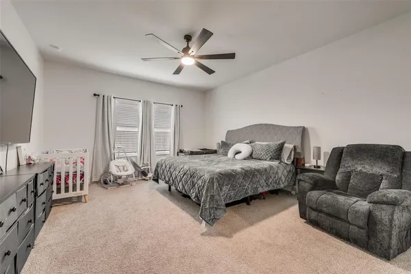 a spacious bedroom with a bed a couch and dresser
