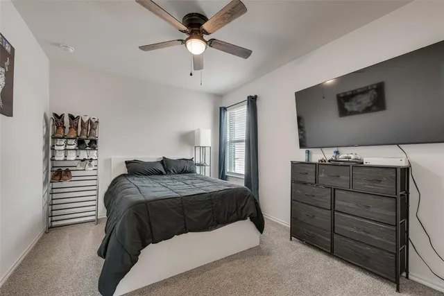 a bedroom with a bed and a flat tv screen on dresser