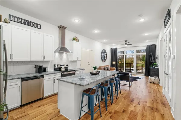 a kitchen with granite countertop a table chairs stove and cabinets