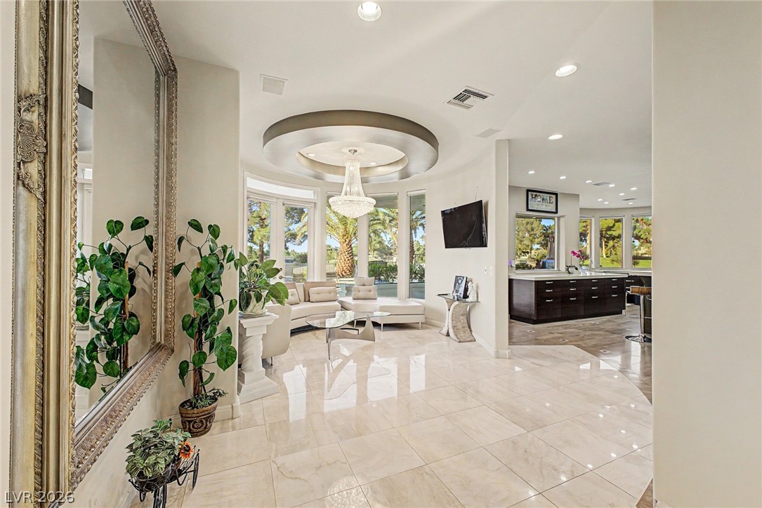 46 Gulf Stream Court Las Vegas, NV 89113 - Photo 15 of 62 This living space features high ceilings, recessed lighting, and expansive windows showcasing lush outdoor views.