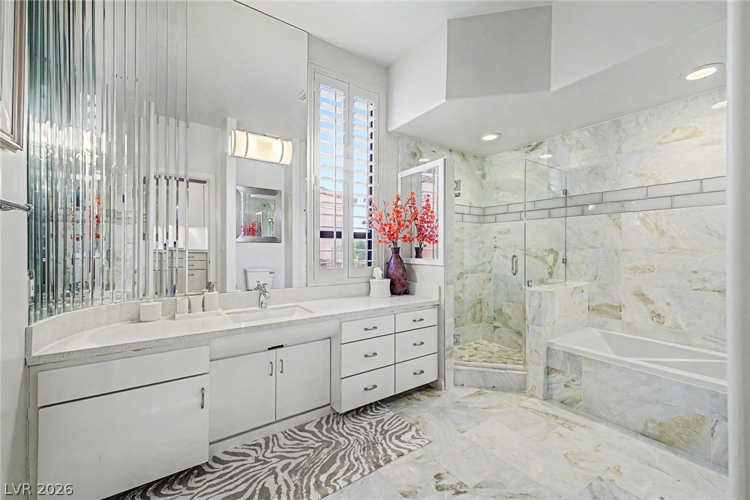 46 Gulf Stream Court Las Vegas, NV 89113 - Photo 26 of 62 This primary bathroom boasts elegant marble finishes, a spacious walk-in shower, and a large soaking tub.