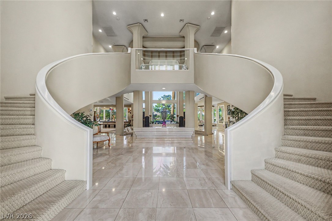 46 Gulf Stream Court Las Vegas, NV 89113 - Photo 3 of 62 Enter into a grand foyer featuring a dual curved staircase and polished tile flooring.