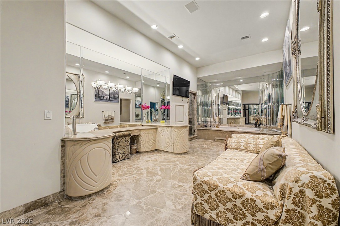 46 Gulf Stream Court Las Vegas, NV 89113 - Photo 38 of 62 This spacious primary bathroom features sleek vanities, a soaking tub, and elegant tile flooring.