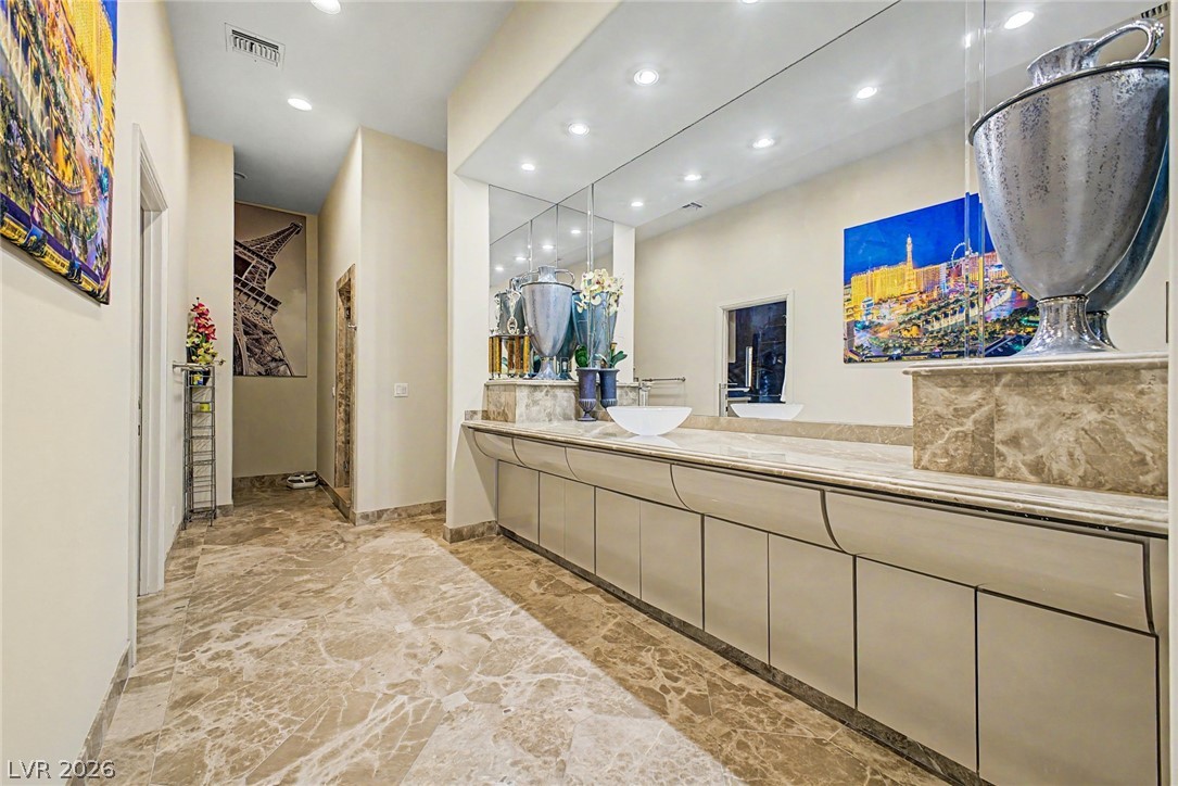 46 Gulf Stream Court Las Vegas, NV 89113 - Photo 46 of 62 Elegant hallway leading to a contemporary bathroom with dual sinks and ample counter space.