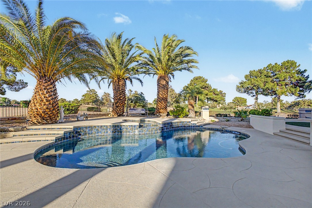 46 Gulf Stream Court Las Vegas, NV 89113 - Photo 61 of 62 This outdoor oasis features a freeform pool surrounded by lush landscaping and mature palm trees.