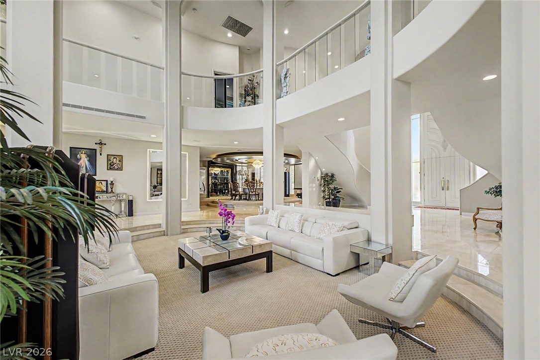 46 Gulf Stream Court Las Vegas, NV 89113 - Photo 8 of 62 This living room offers an inviting atmosphere with high ceilings and a grand spiral staircase.