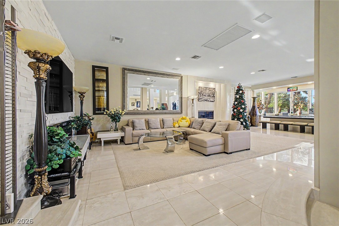46 Gulf Stream Court Las Vegas, NV 89113 - Photo 9 of 62 This living area features ample space, a fireplace, and large windows that offer views of the outdoors.