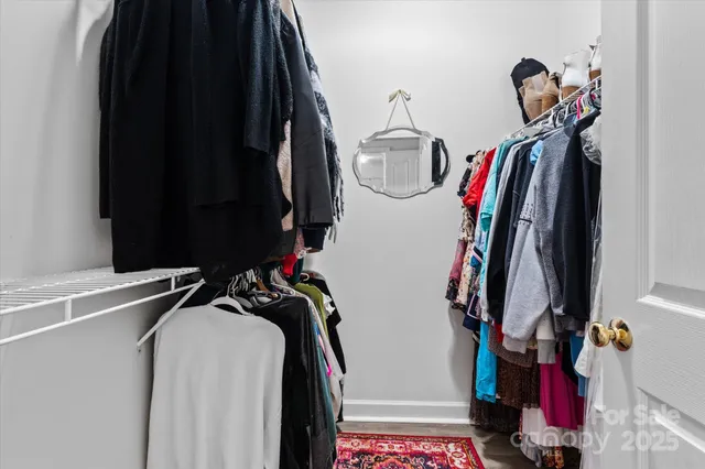 a view of walk in closet with clothes and shoes
