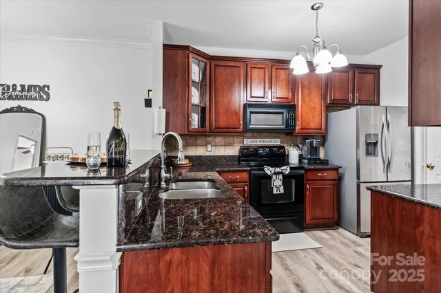 a kitchen with stainless steel appliances granite countertop a stove refrigerator and a sink