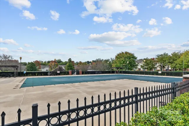 a front view of a house with swimming pool and garden