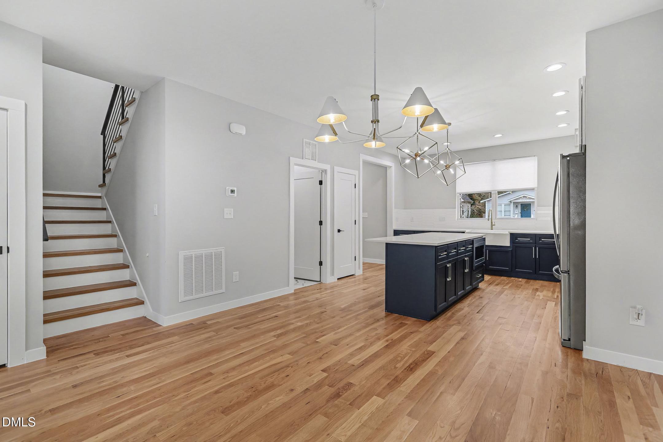 1508 East Jones Street Raleigh, NC 27610 - Photo 13 of 38 a view of a kitchen with granite countertop wooden floor a ceiling fan and stainless steel appliances