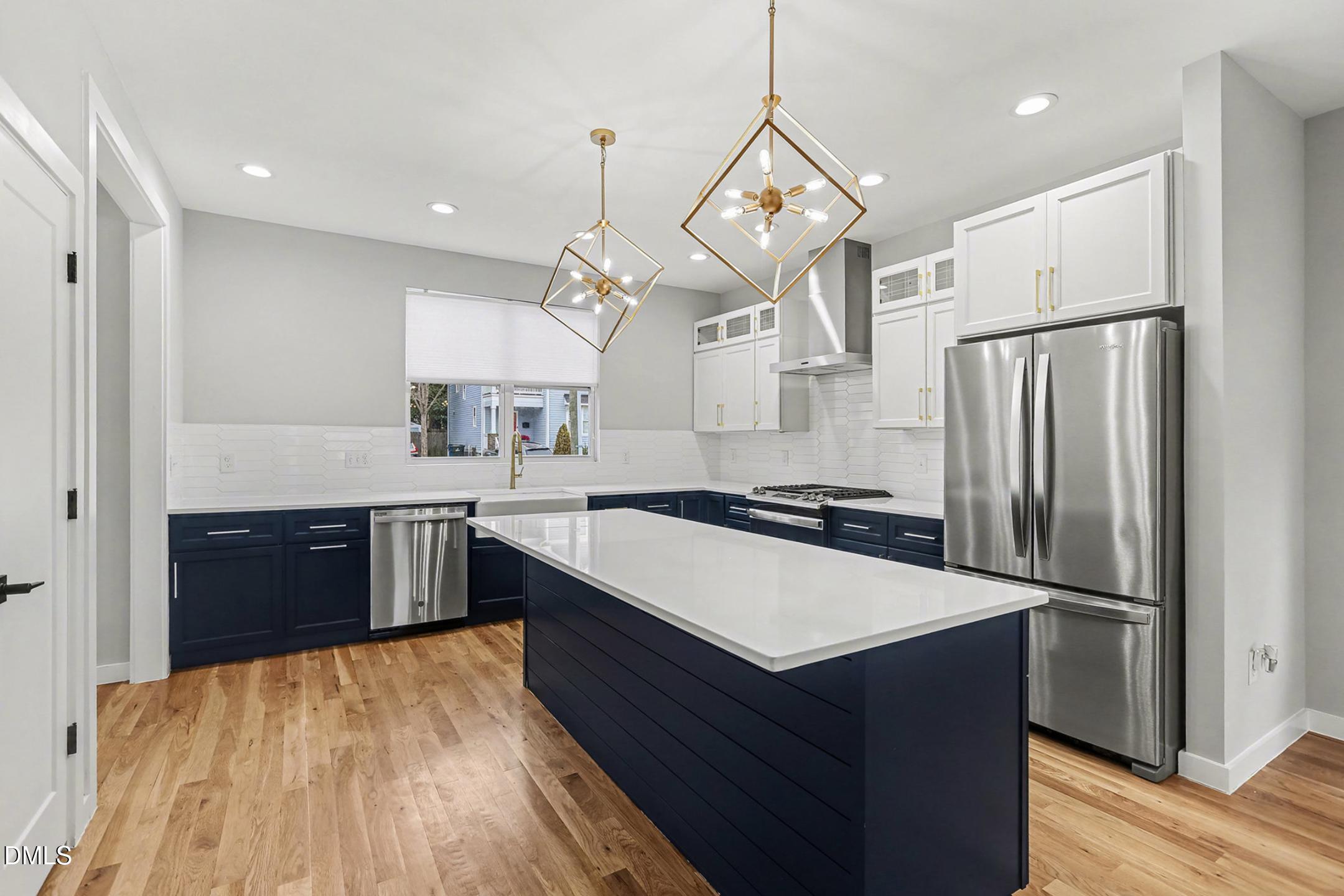 1508 East Jones Street Raleigh, NC 27610 - Photo 16 of 38 a kitchen with stainless steel appliances granite countertop a refrigerator a sink dishwasher a kitchen island with wooden cabinets and floor