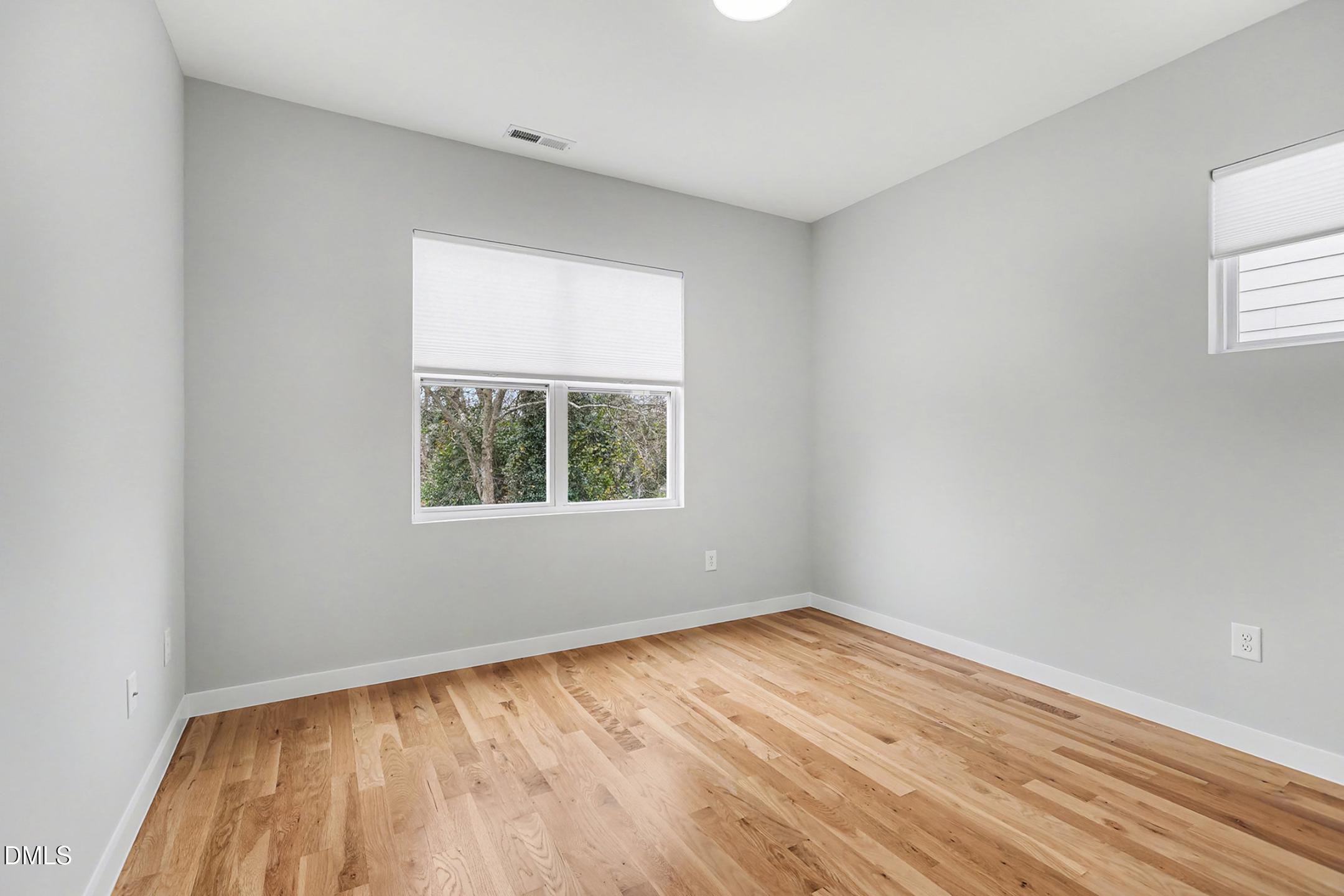 1508 East Jones Street Raleigh, NC 27610 - Photo 22 of 38 an empty room with wooden floor and windows