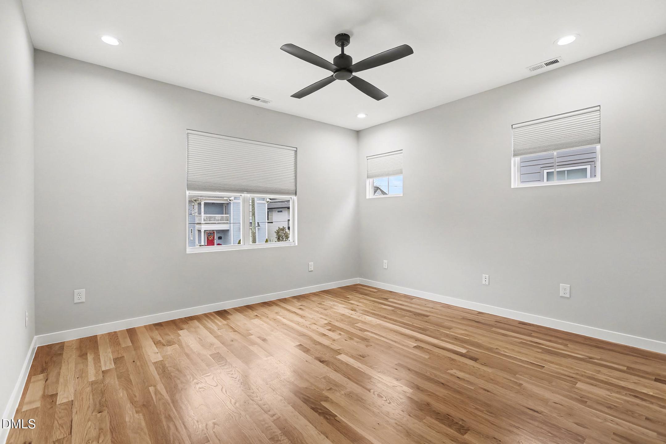 1508 East Jones Street Raleigh, NC 27610 - Photo 26 of 38 an empty room with wooden floor and ceiling fan
