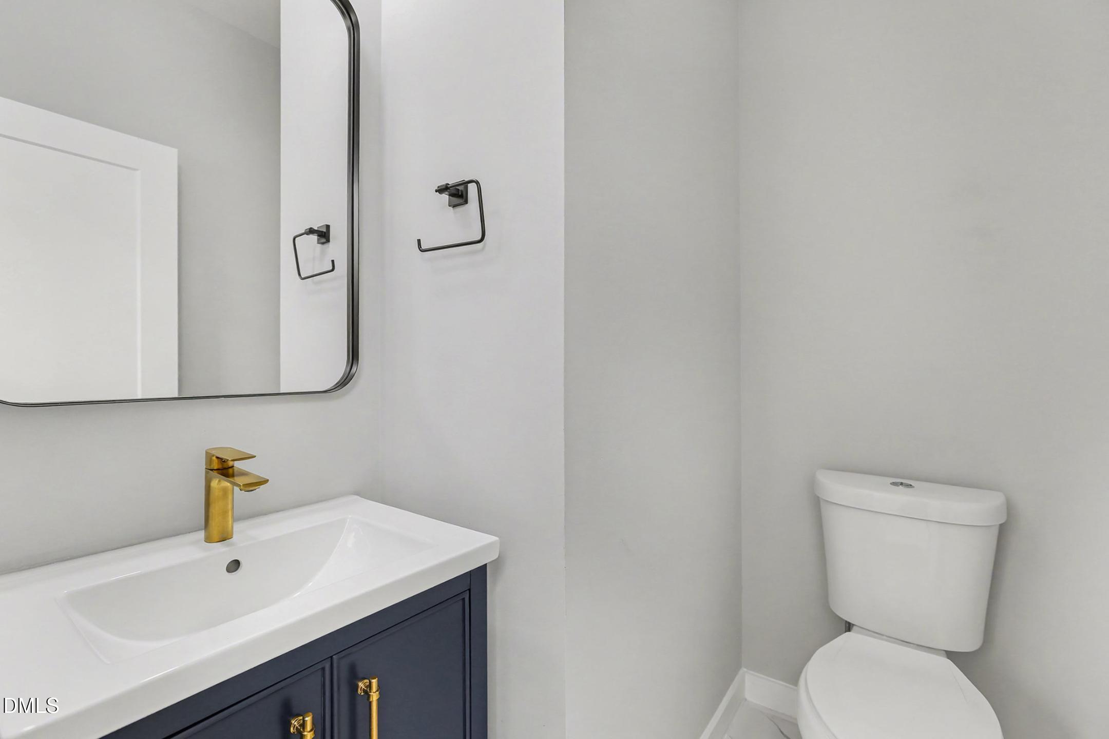 1508 East Jones Street Raleigh, NC 27610 - Photo 34 of 38 a bathroom with a sink a toilet and mirror