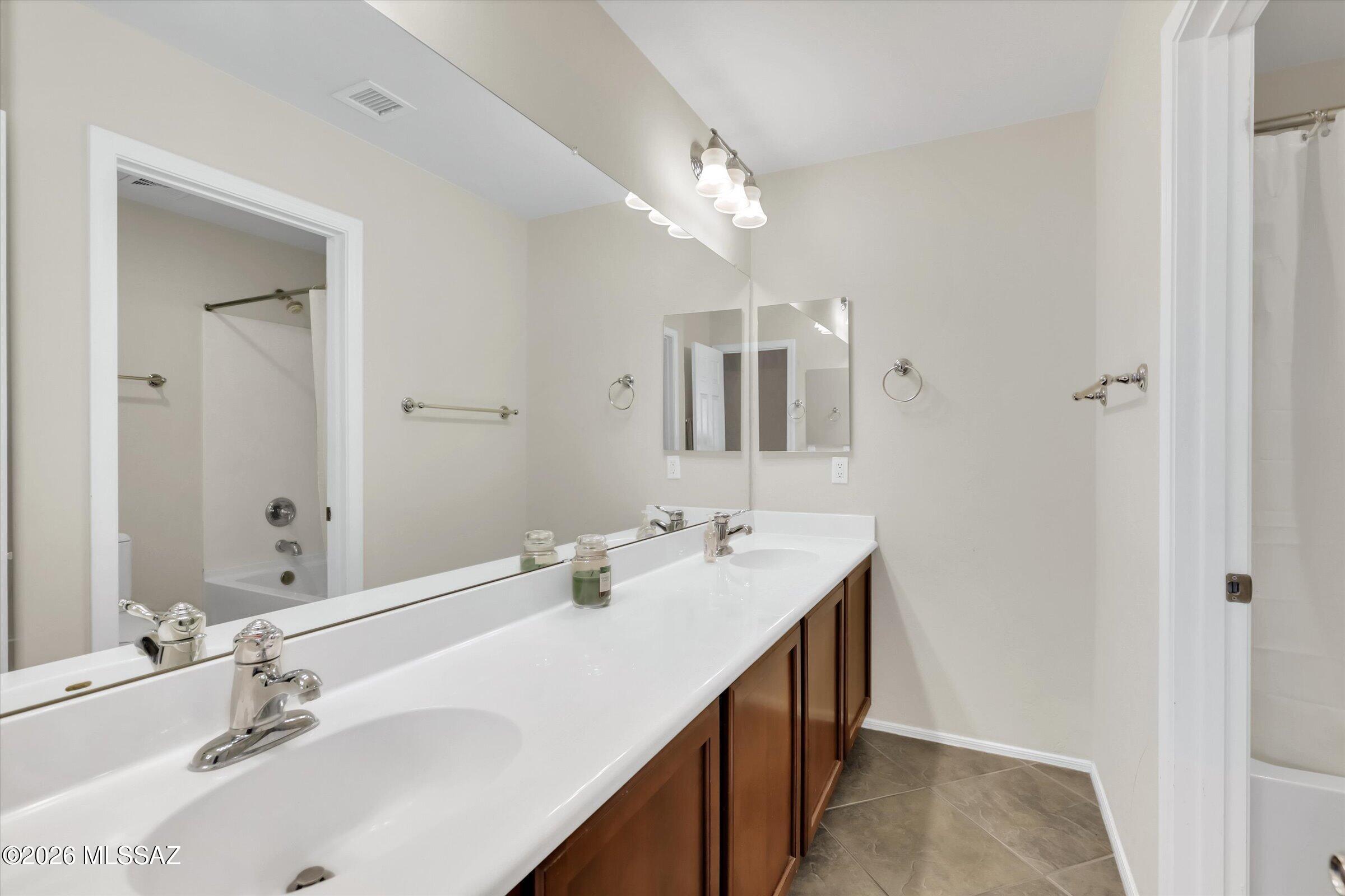 6095 South Jakemp Trail Tucson, AZ 85747 - Photo 35 of 52 a bathroom with double vanity sinks a vanity and a large mirror