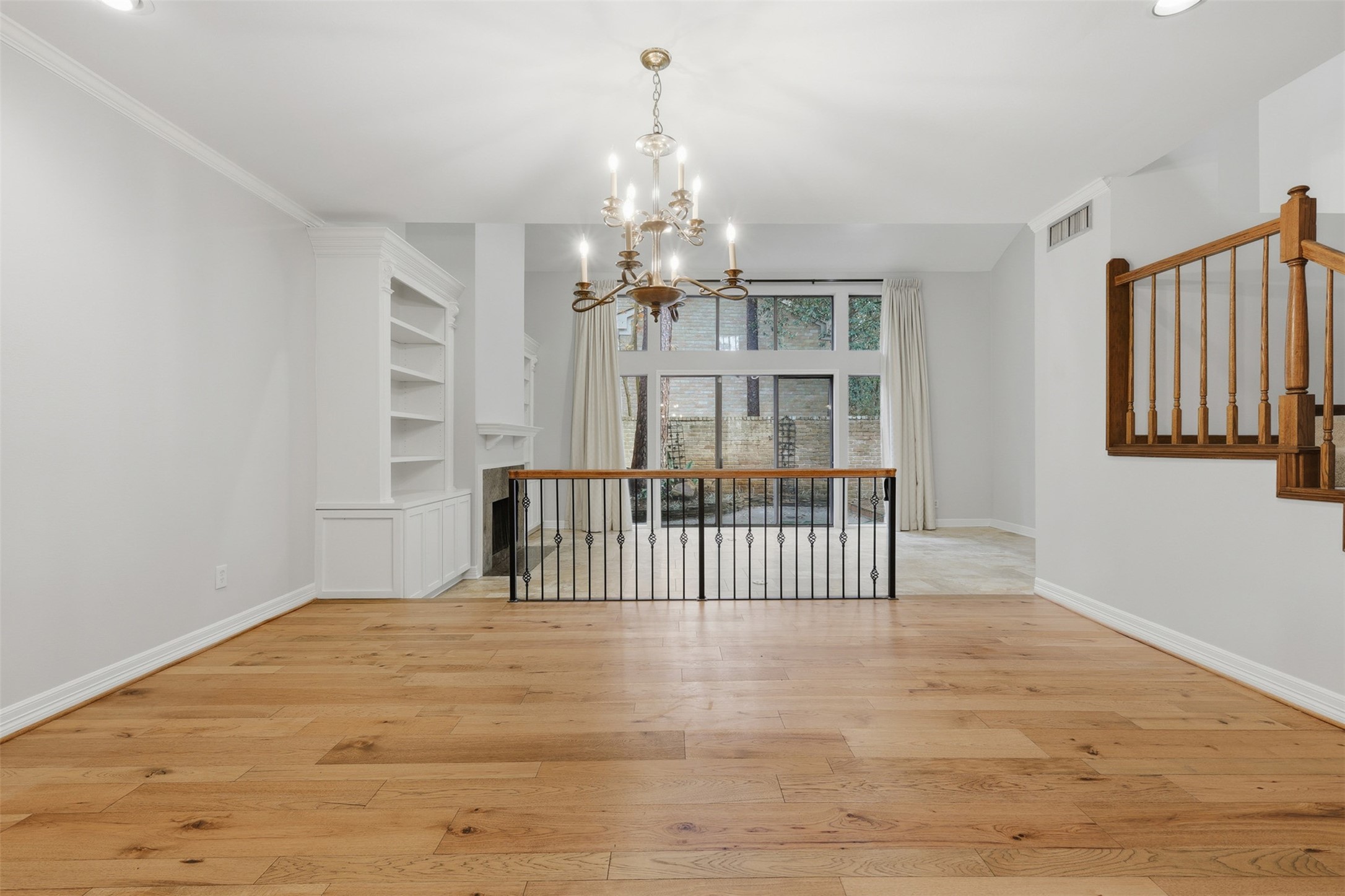 201 Vanderpool Lane, Unit 122 Houston, TX 77024 - Photo 4 of 35 a view of a room with wooden floor windows and a chandelier