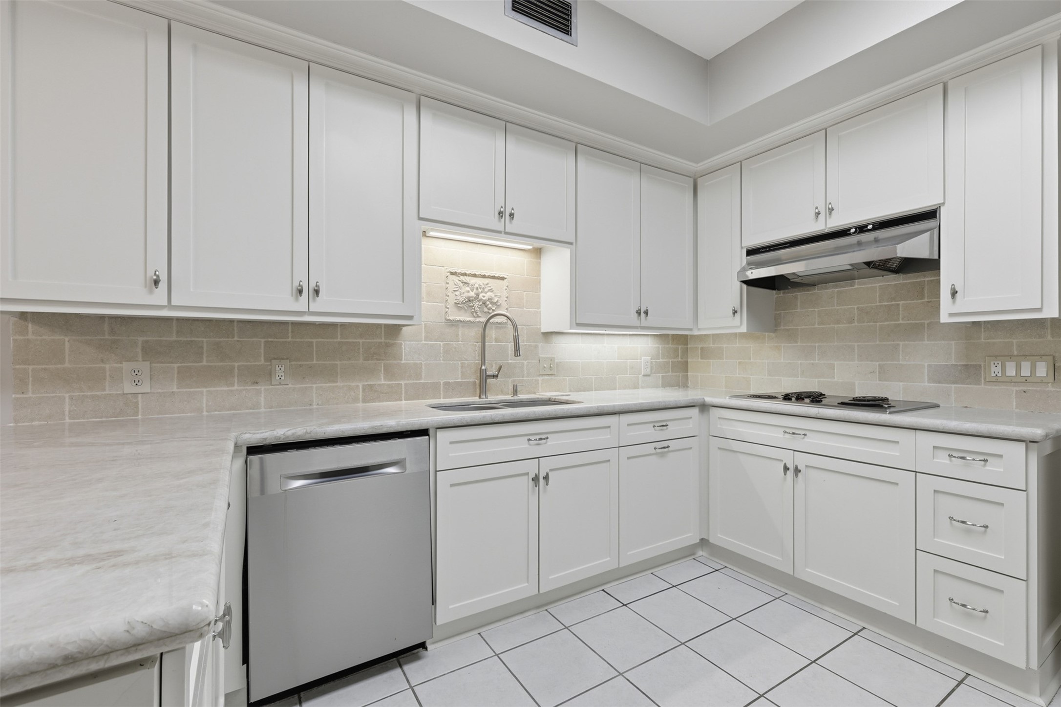 201 Vanderpool Lane, Unit 122 Houston, TX 77024 - Photo 10 of 35 a kitchen with white cabinets stainless steel appliances and a sink