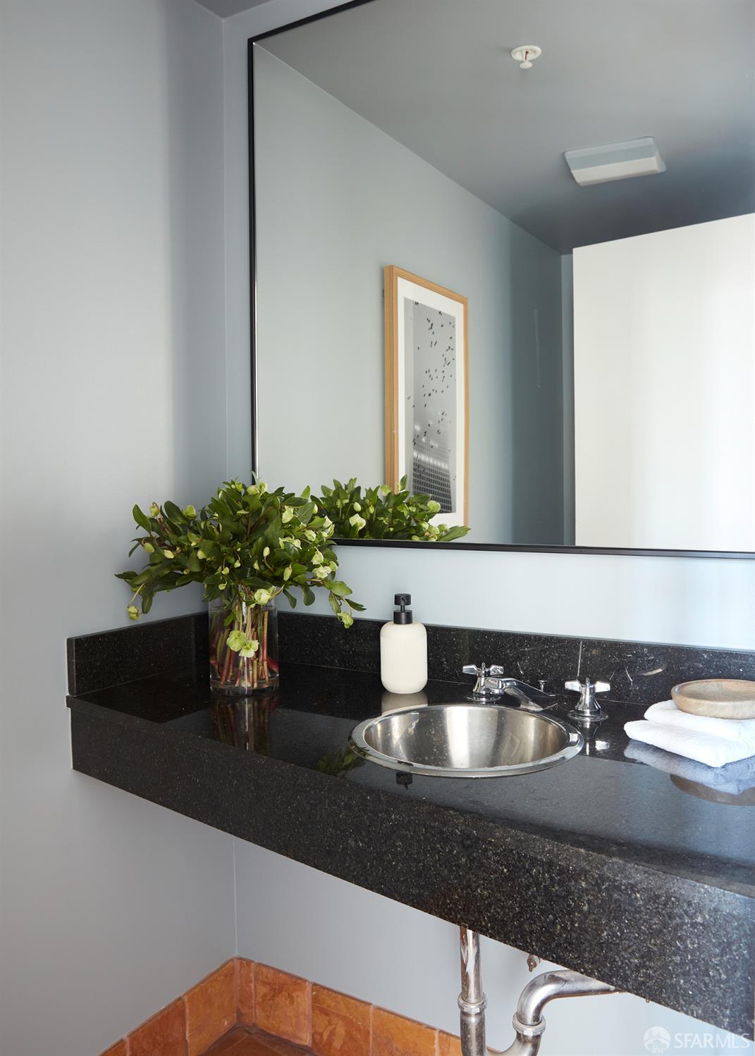 999 16th Street, Unit 11 San Francisco, CA 94107 - Photo 11 of 15 a bathroom with a granite countertop sink a mirror and vanity
