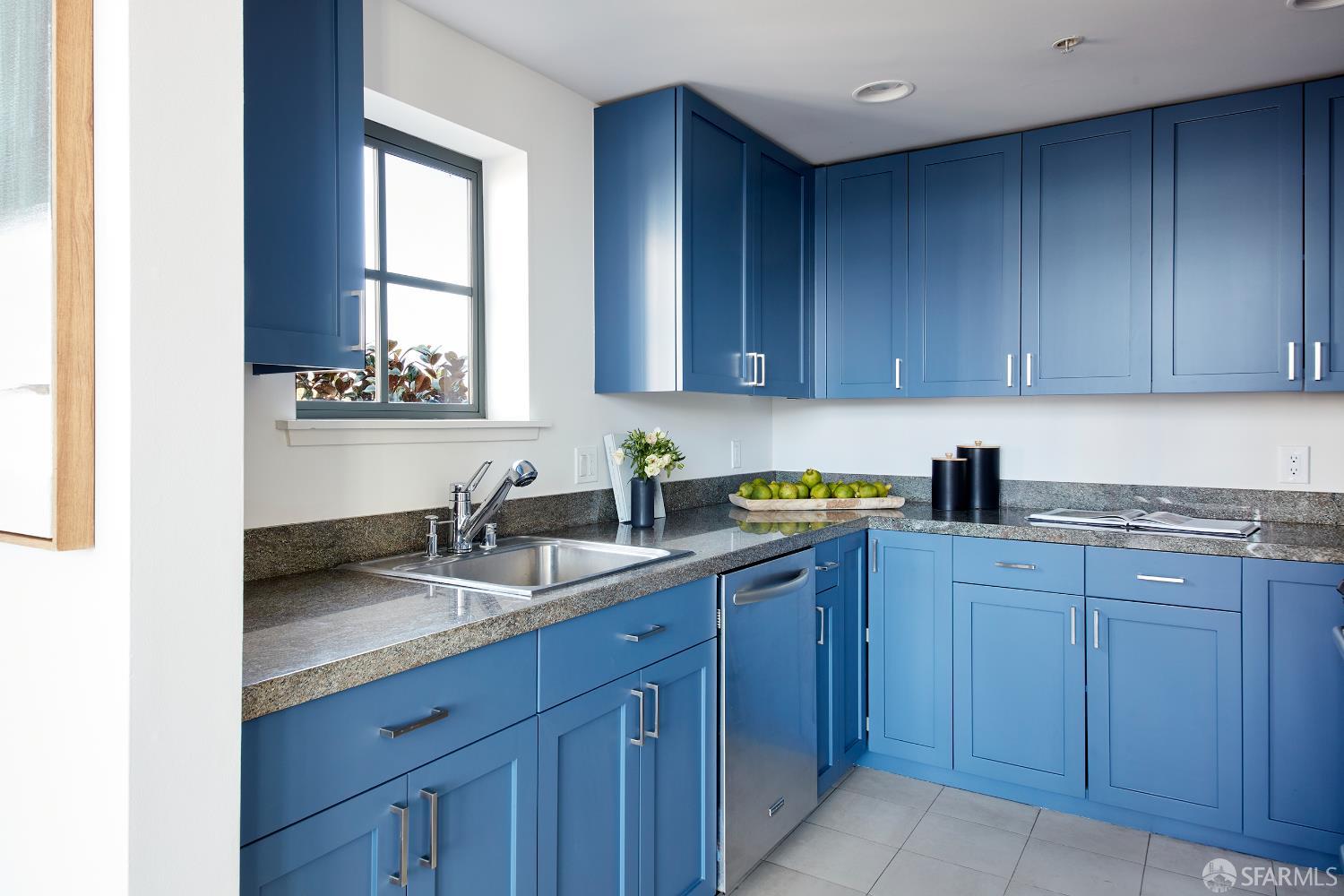 999 16th Street, Unit 11 San Francisco, CA 94107 - Photo 7 of 15 a kitchen with stainless steel appliances granite countertop a sink and wooden cabinets