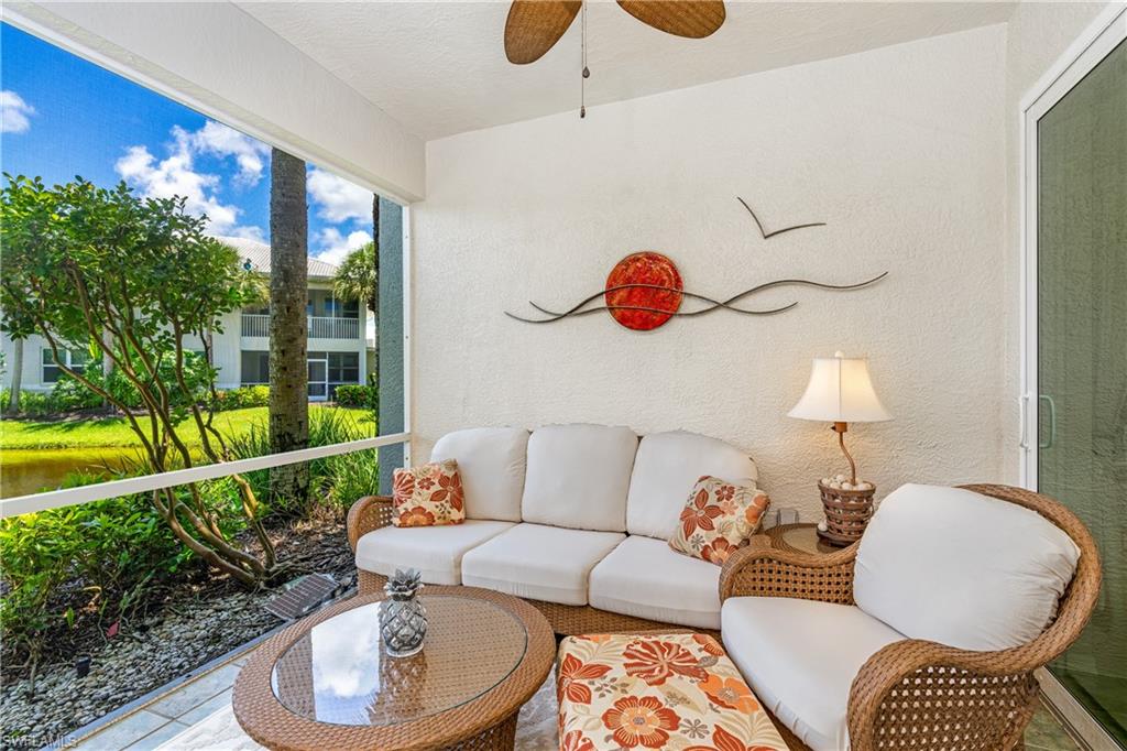 4680 Hawks Nest Way, Unit D103 Naples, FL 34114 - Photo 12 of 41 a living room with furniture and a floor to ceiling window