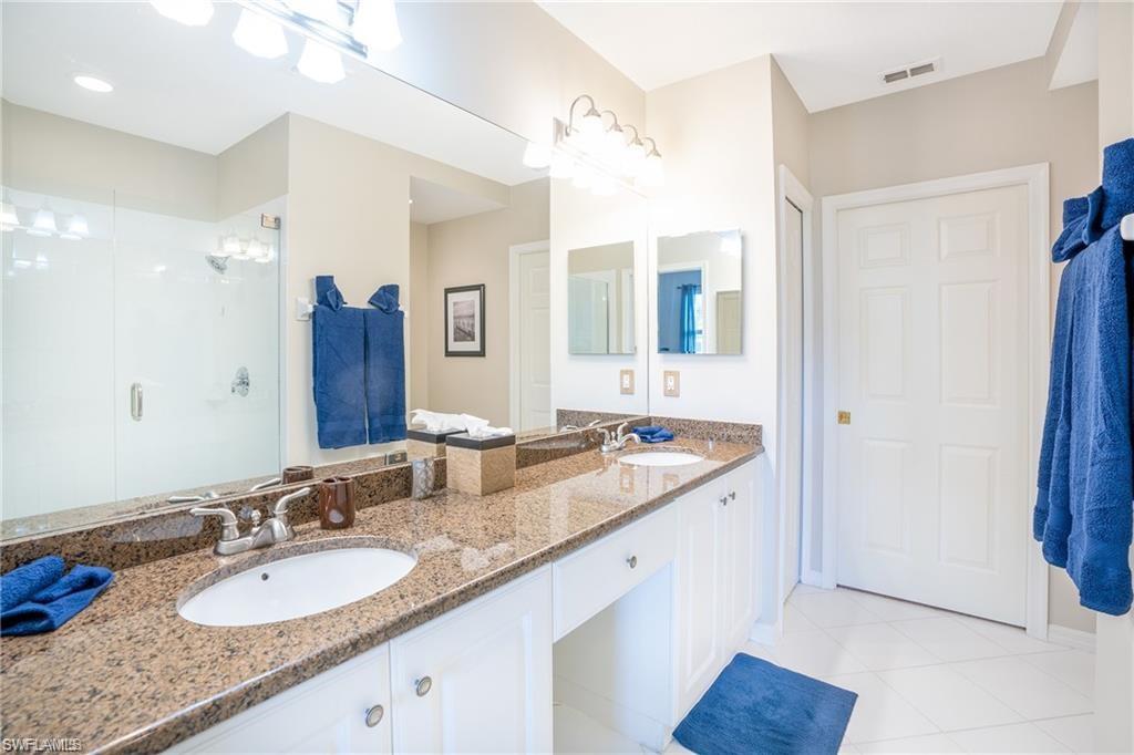 4680 Hawks Nest Way, Unit D103 Naples, FL 34114 - Photo 15 of 41 a bathroom with a granite countertop sink and a mirror