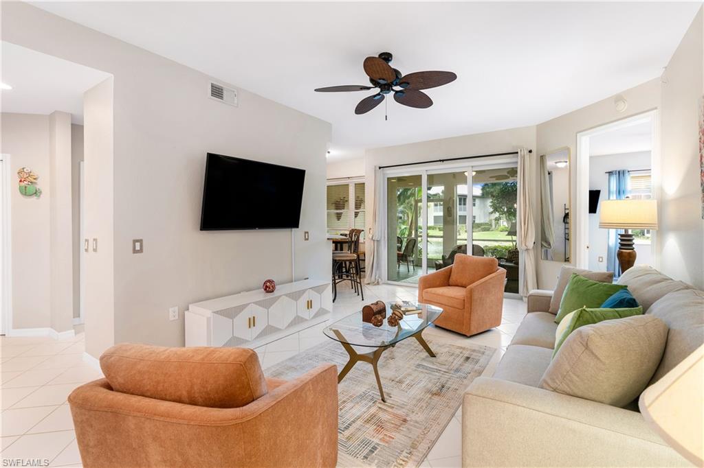 4680 Hawks Nest Way, Unit D103 Naples, FL 34114 - Photo 3 of 41 a living room with furniture and a flat screen tv