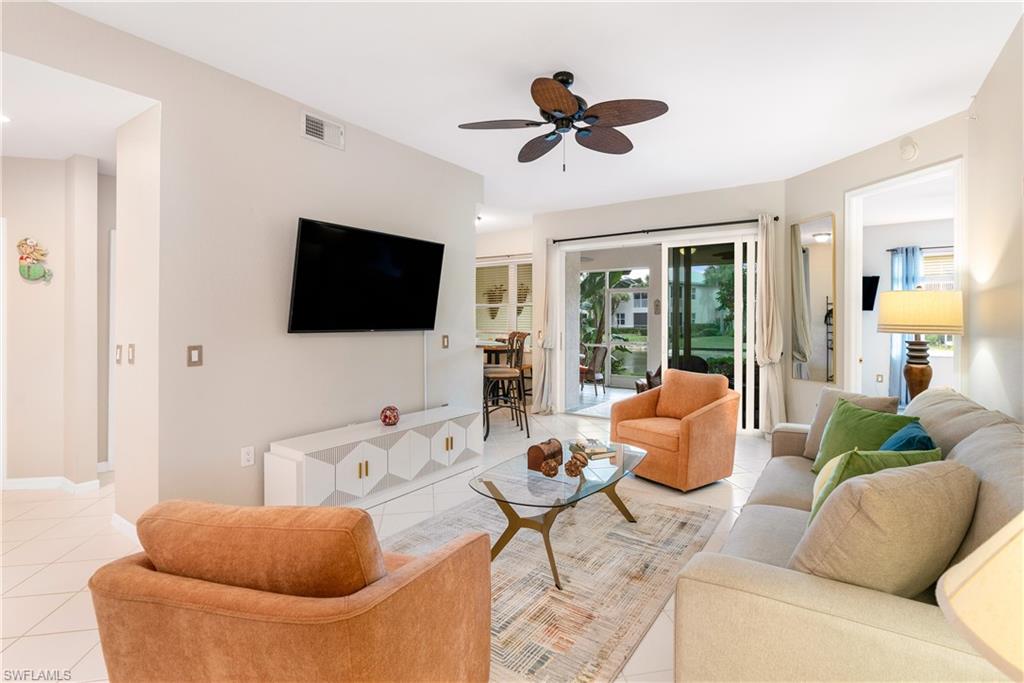 4680 Hawks Nest Way, Unit D103 Naples, FL 34114 - Photo 4 of 41 a living room with furniture and a flat screen tv
