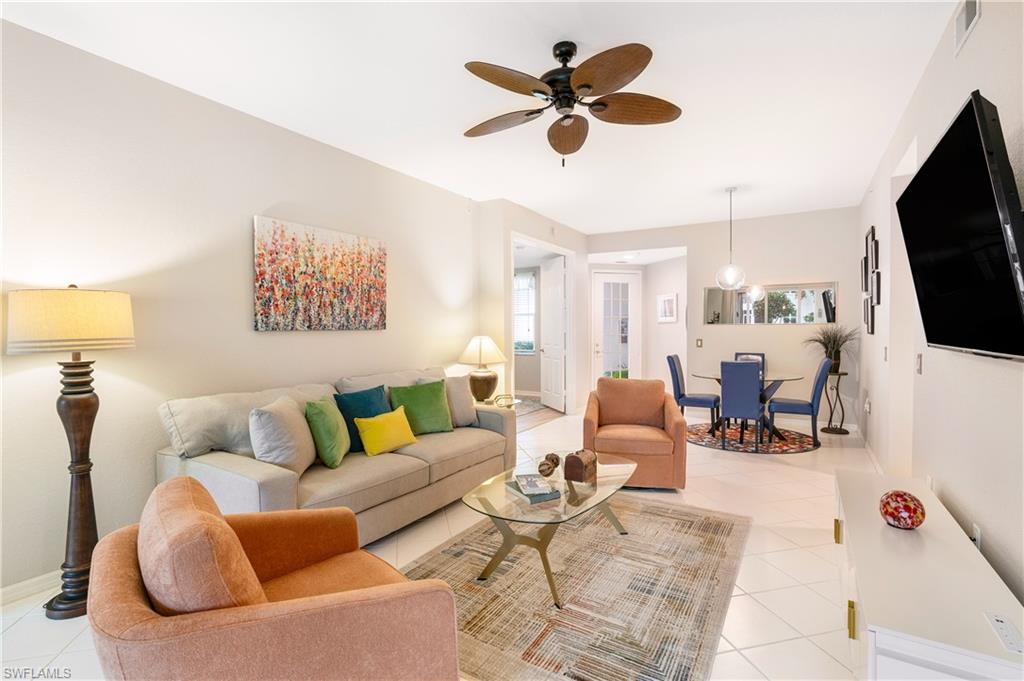 4680 Hawks Nest Way, Unit D103 Naples, FL 34114 - Photo 5 of 41 a living room with furniture kitchen view and a flat screen tv