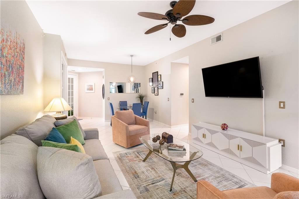 4680 Hawks Nest Way, Unit D103 Naples, FL 34114 - Photo 6 of 41 a living room with furniture and a flat screen tv