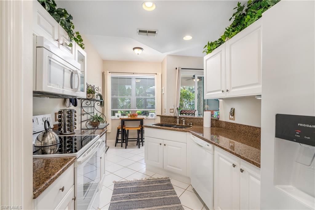 4680 Hawks Nest Way, Unit D103 Naples, FL 34114 - Photo 9 of 41 a kitchen with sink a stove and cabinets