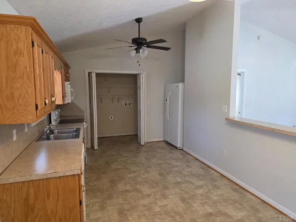 an empty room with a fireplace and a chandelier fan