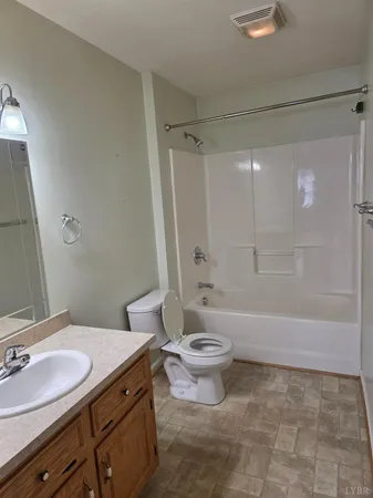 a bathroom with a granite countertop sink toilet a mirror and a bathtub