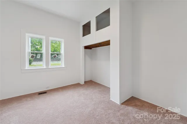 an empty room with windows and closet