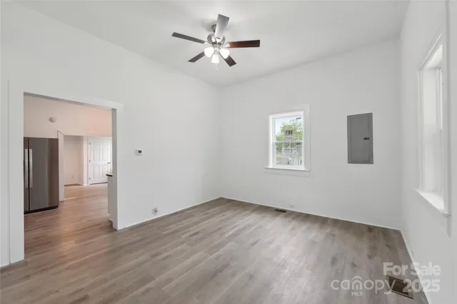 a view of a big room with wooden floor and a ceiling fan