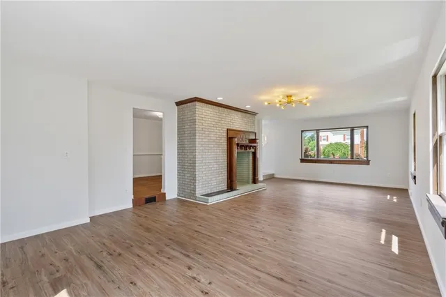an empty room with wooden floor and a window