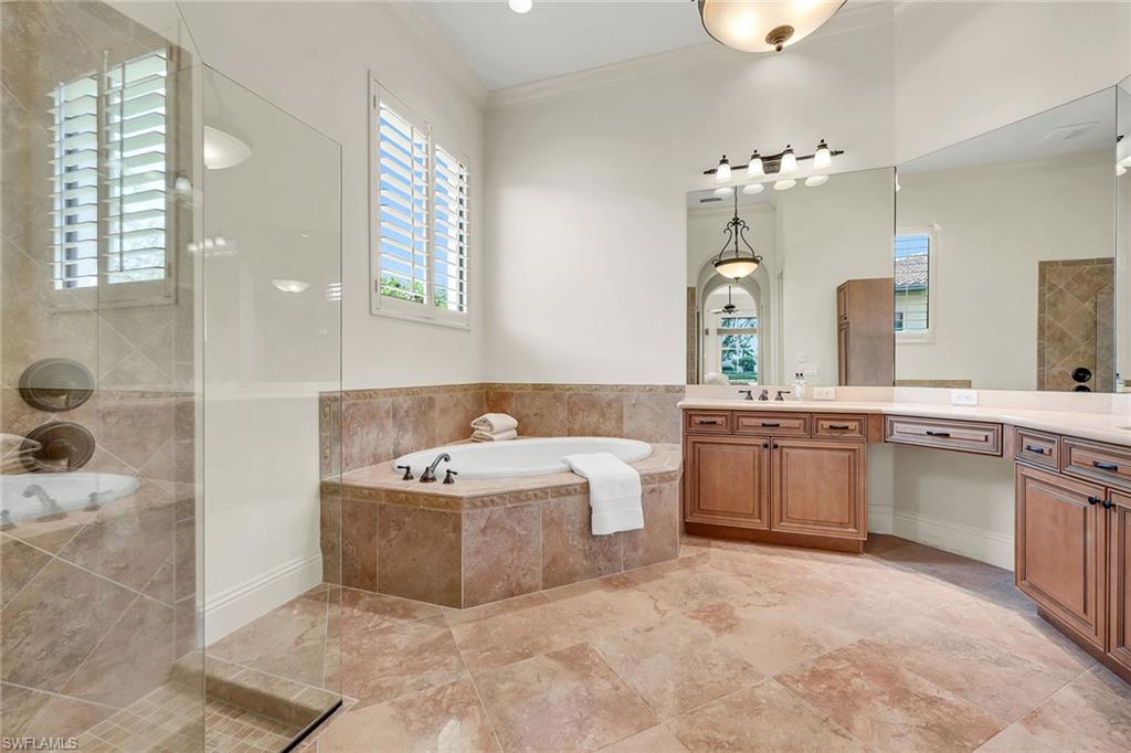 16839 Cabreo Drive Naples, FL 34110 - Photo 12 of 23 a bathroom with a double vanity sink a mirror and a bathtub