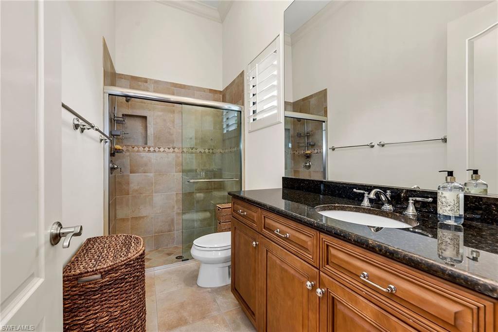 16839 Cabreo Drive Naples, FL 34110 - Photo 13 of 23 a bathroom with a granite countertop sink a toilet a mirror and shower