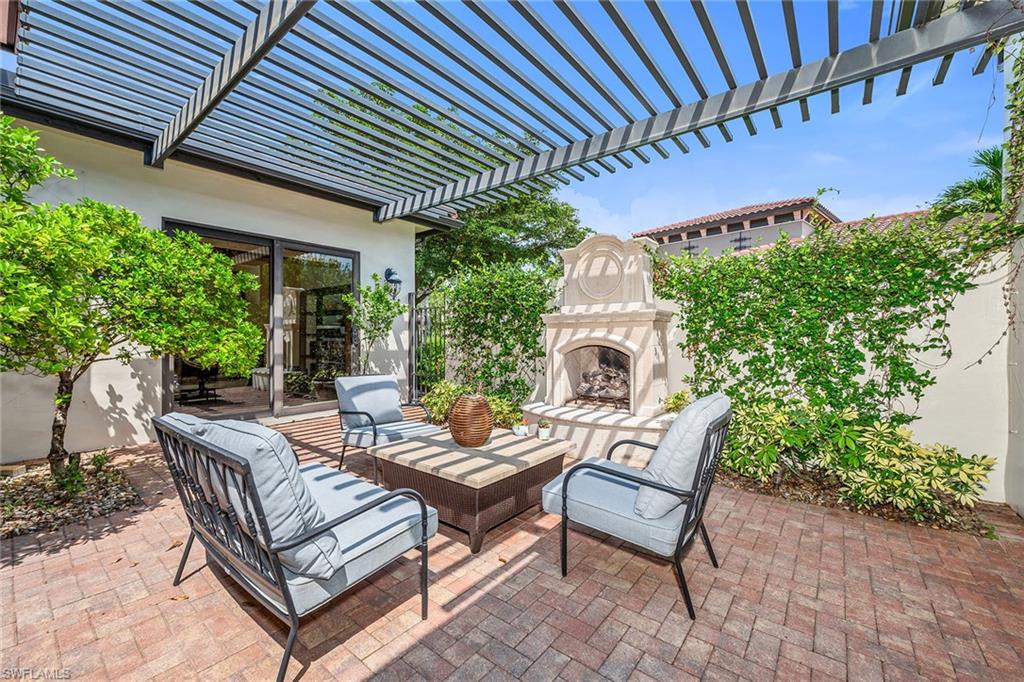 16839 Cabreo Drive Naples, FL 34110 - Photo 19 of 23 a view of a patio with a table and chairs and potted plants