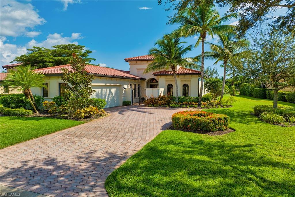 16839 Cabreo Drive Naples, FL 34110 - Photo 22 of 23 a front view of a house with a yard and potted plants