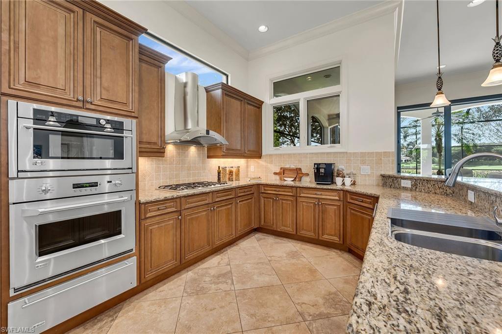 16839 Cabreo Drive Naples, FL 34110 - Photo 7 of 23 a kitchen with stainless steel appliances granite countertop a stove sink and cabinets