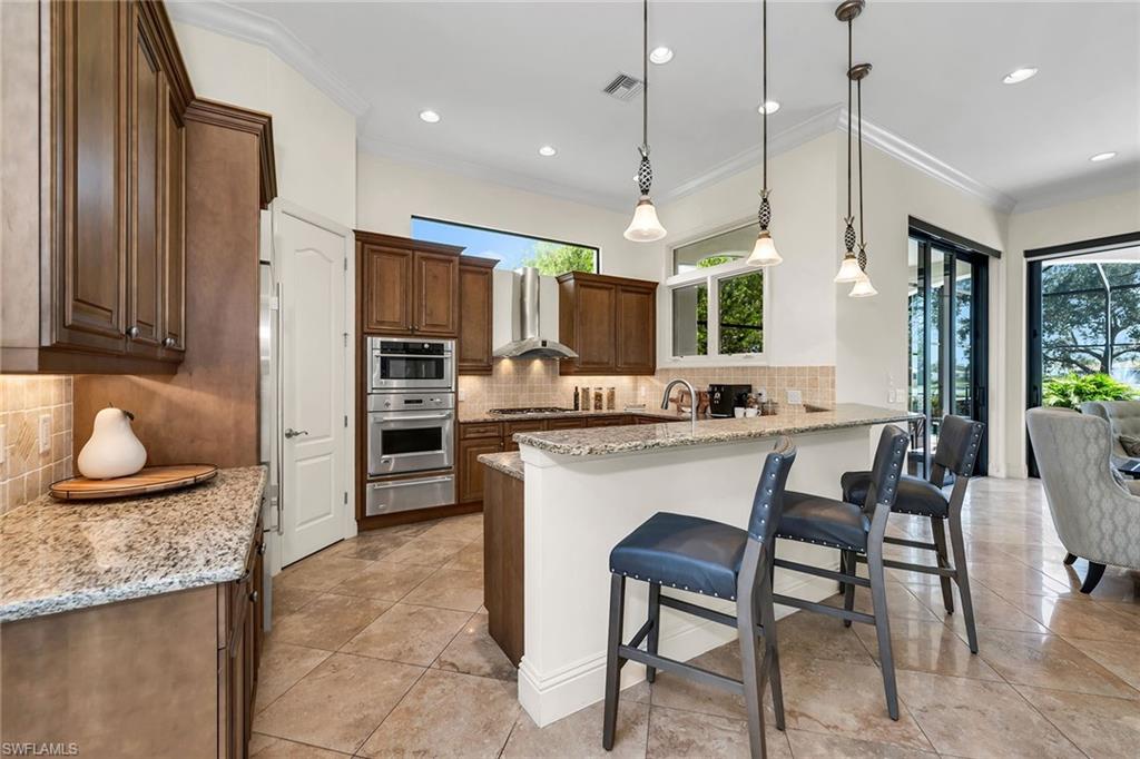 16839 Cabreo Drive Naples, FL 34110 - Photo 8 of 23 a kitchen with a table and chairs in it