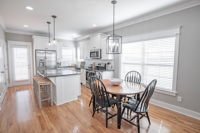 379 Beechcroft Road Spring Hill, TN 37174 - Photo 15 of 18 a dining room with stainless steel appliances granite countertop a dining table chairs and wooden floor
