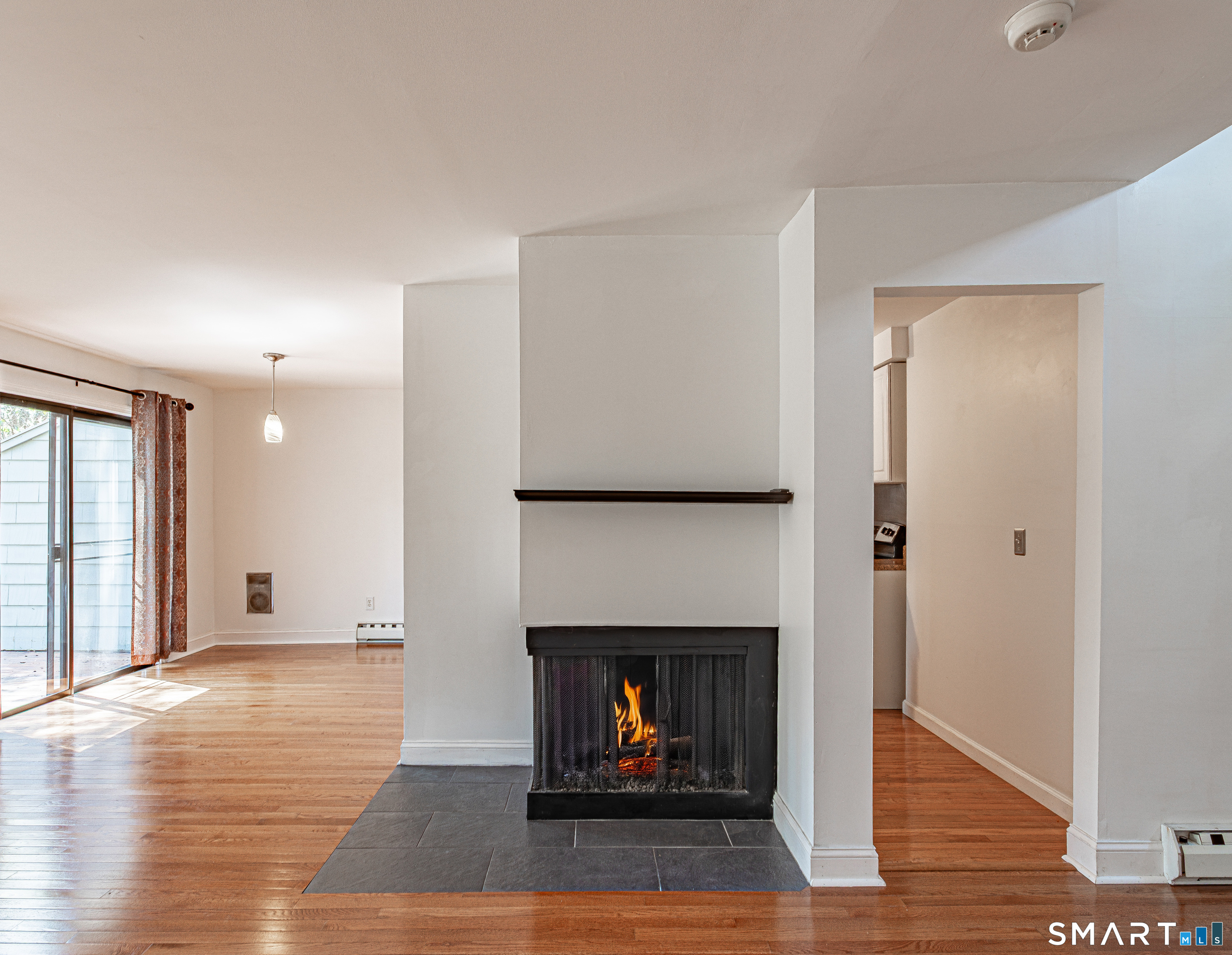 127 Old Farms Road, Unit 127 Torrington, CT 06790 - Photo 11 of 32 a living room with a fireplace and wooden floor